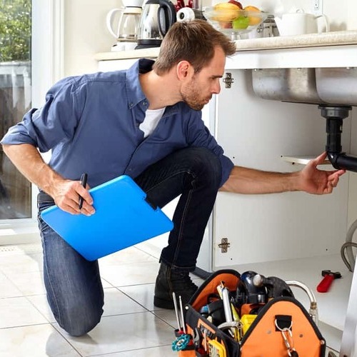 A residential plumber checks pipes.
