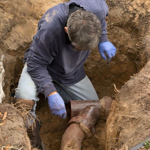 Plumber repairs an underground line.